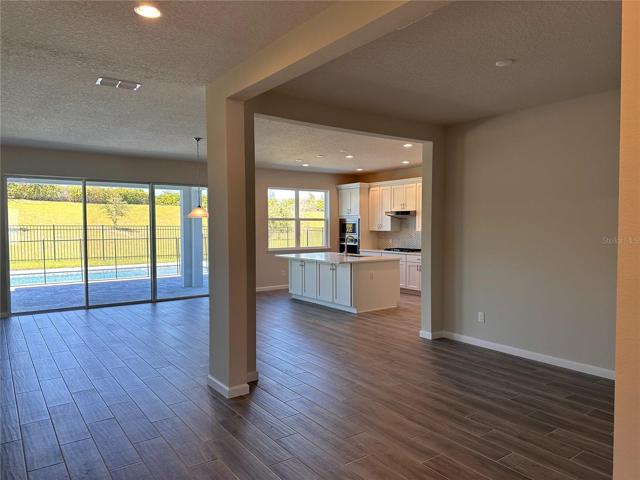Wide hallway opens up to open concept dining room, great room, and kitchen