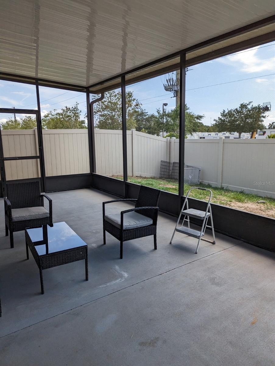 screened patio with fully fenced in yard.
