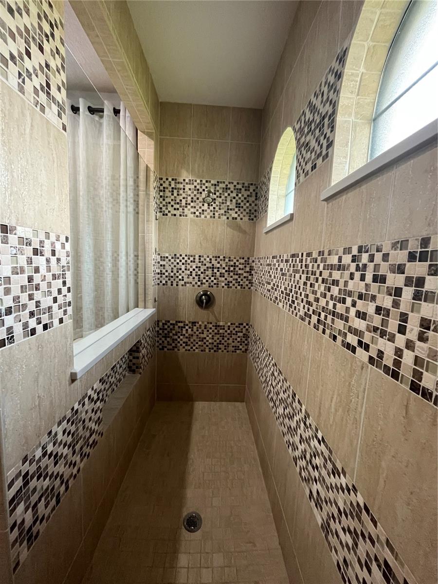 Oversized Roll-In Shower with Designer Tile Insets, Niches and Seat