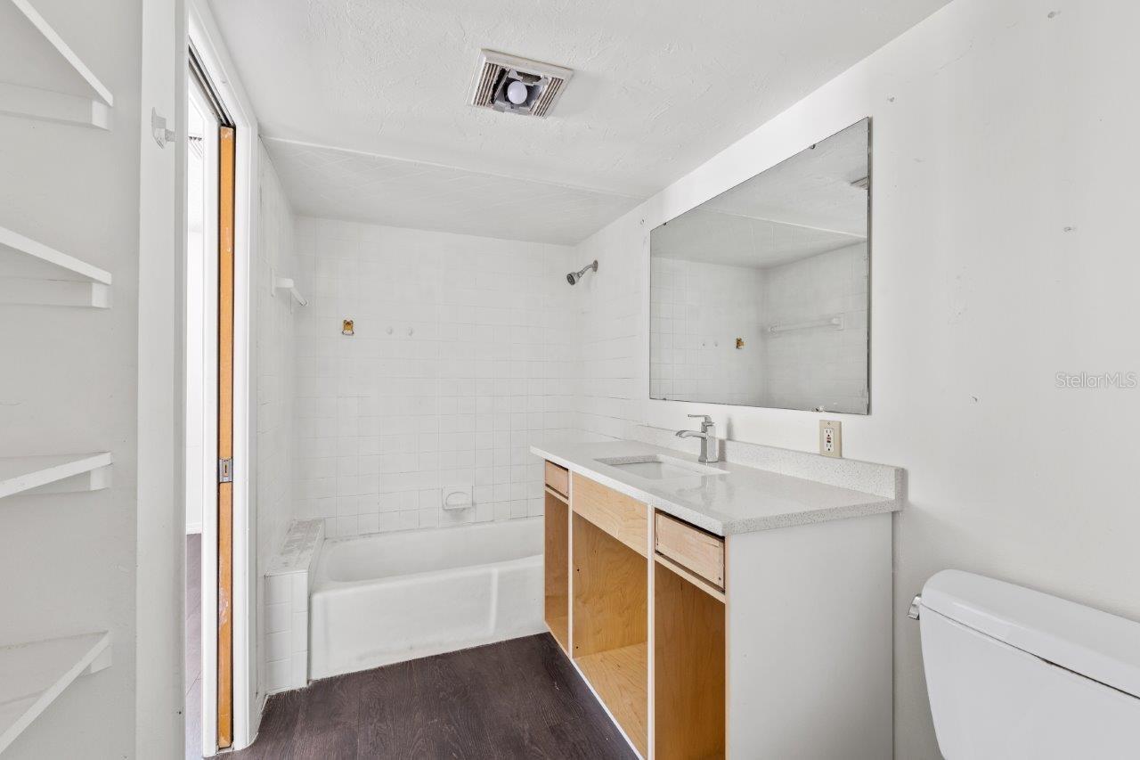 Left Unit: Owners en suite bathroom featuring quartz countertops, built-in shelving, and a newer faucet.