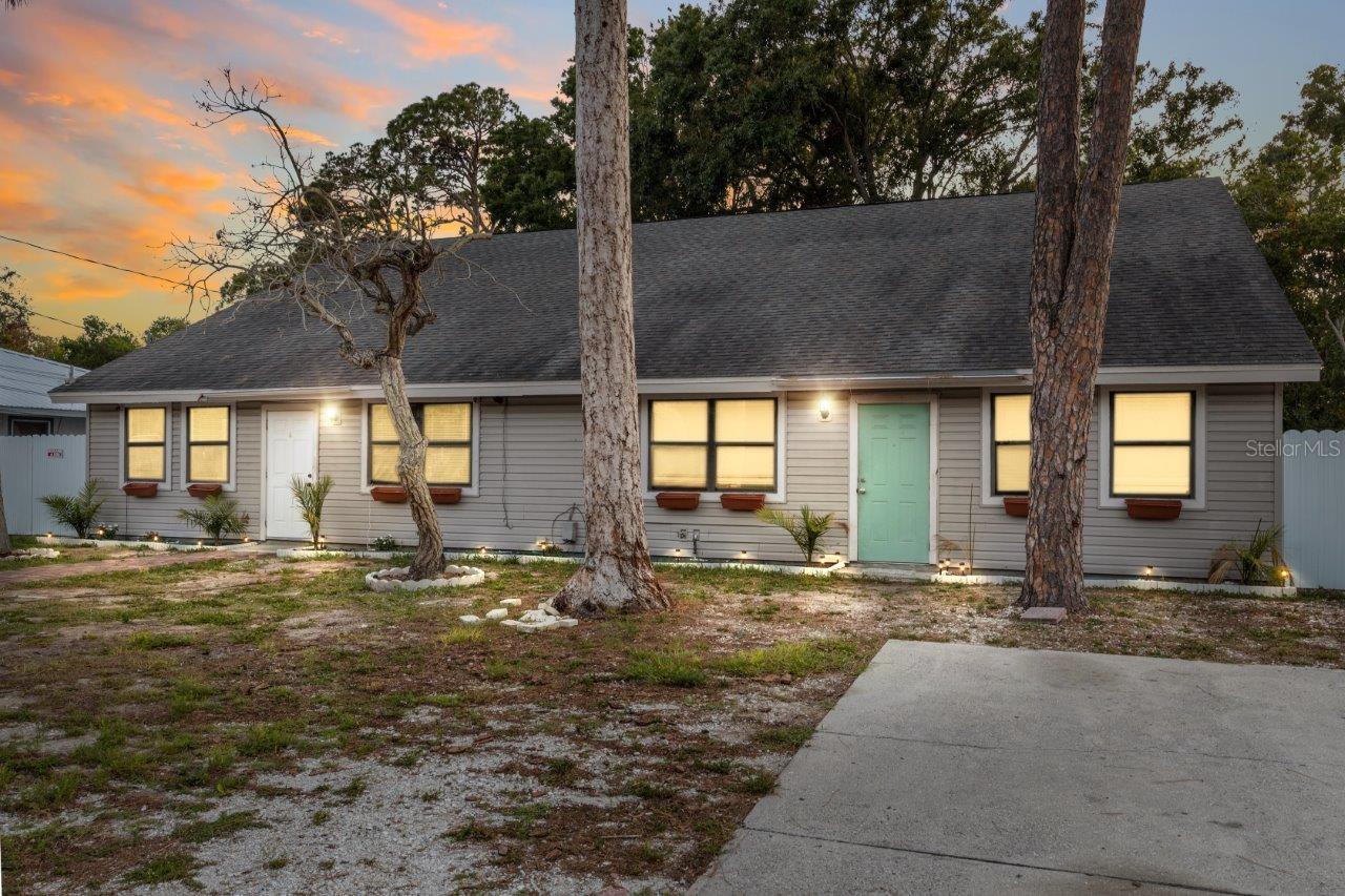 Front Elevation featuring two parking pads, paver sidewalk, gutters, and only a 7 year old roof