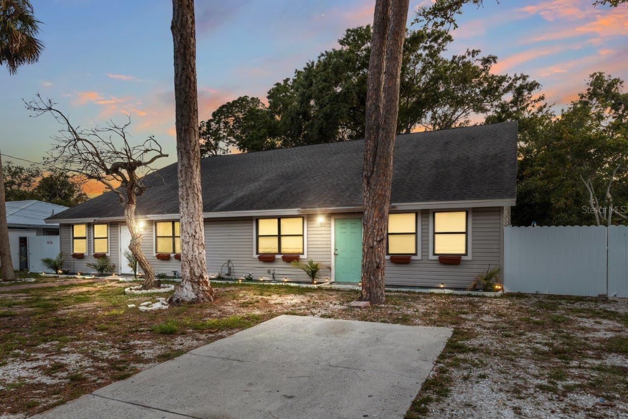Front Elevation featuring two parking pads, paver sidewalk, gutters, and only a 7 year old roof