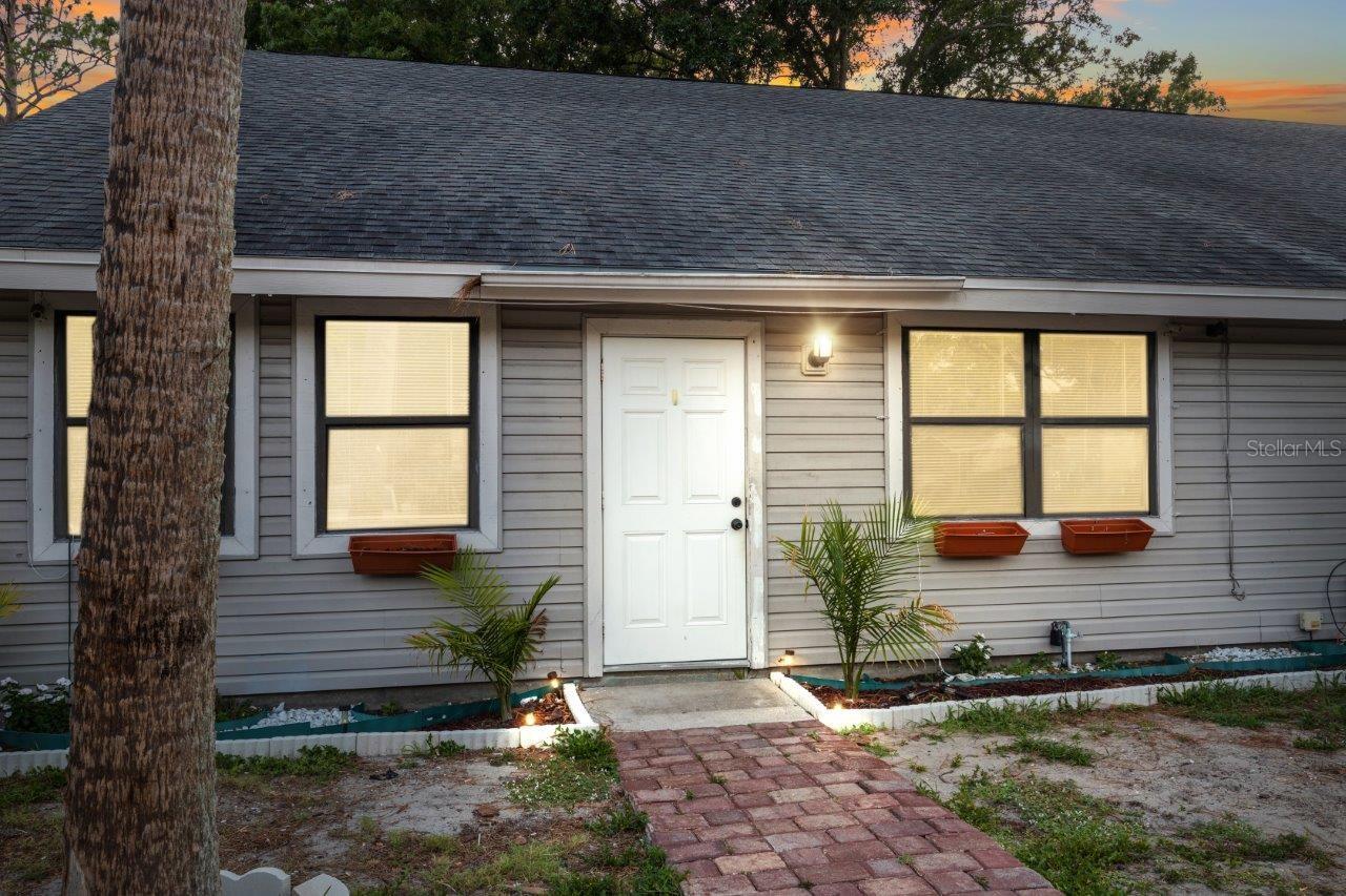 Front Elevation of the left unit featuring two parking pads, paver sidewalk, gutters, and only a 7 year old roof
