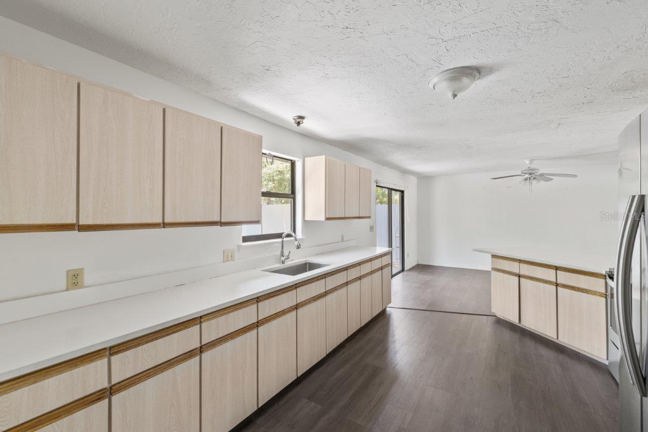 Left Unit: Beautiful kitchen featuring newer whirlpool stainless steel appliances, quartz countertops, an abundance of cabinetry, laundry closet, large pantry, and exterior door to the side yard.