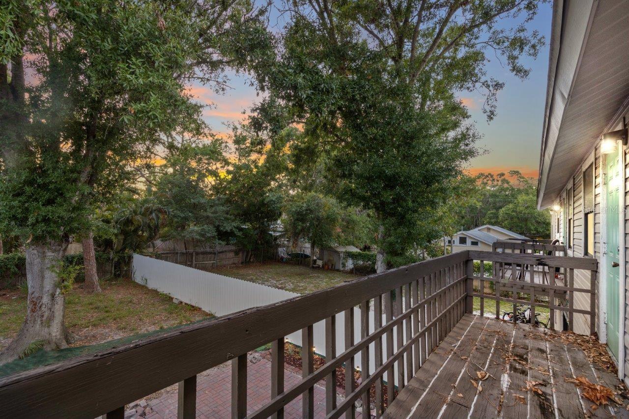 Left Unit: Guest bedroom shared balcony overlooking the large fenced in back yard.