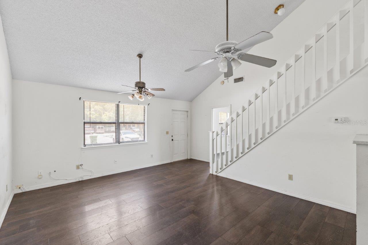 Left Unit: Open floorplan featuring cathedral ceilings up to the second floor, and laminate flooring throughout.