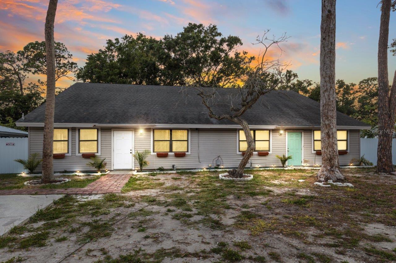 Front Elevation featuring two parking pads, paver sidewalk, gutters, and only a 7 year old roof