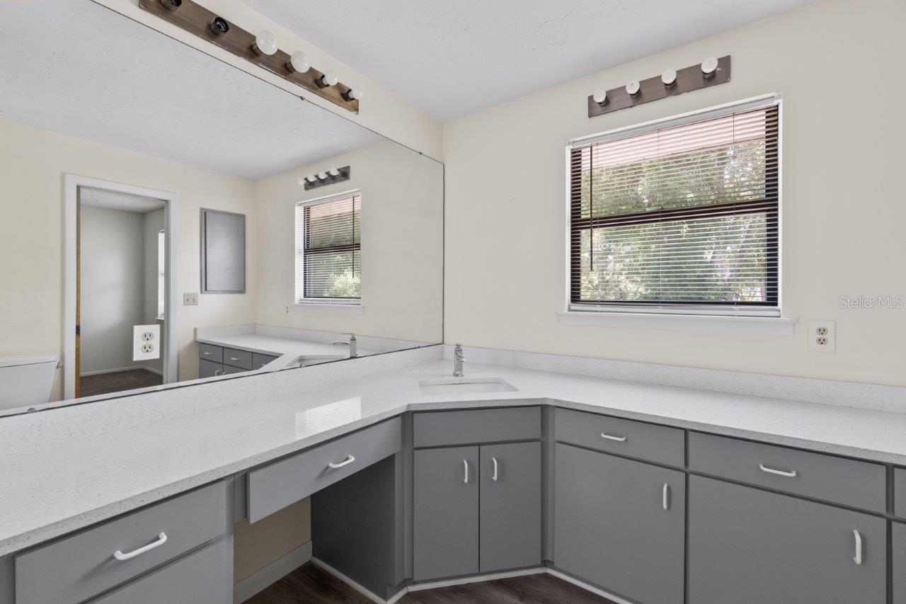Left Unit: Guest Jack and Jill bathroom featuring quartz countertops, extended vanity, and walk-in shower.
