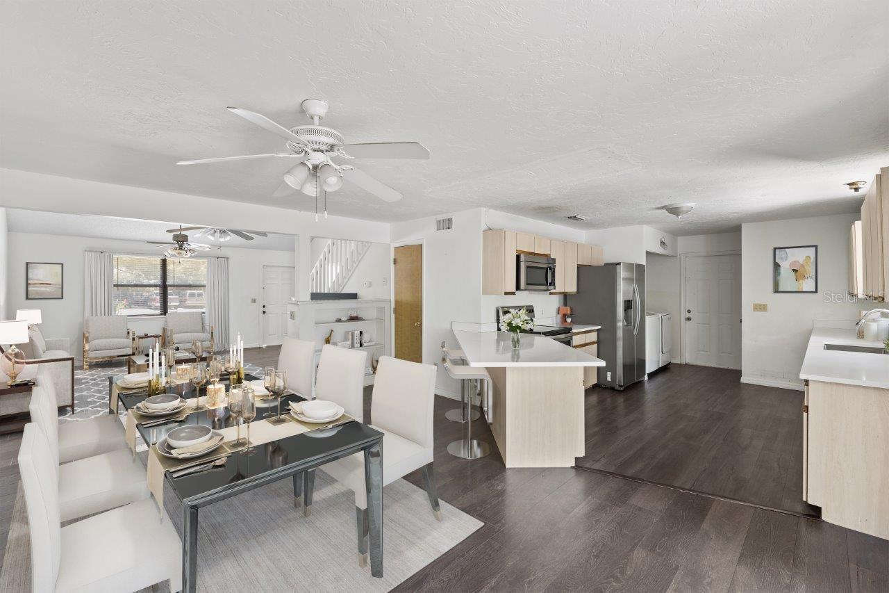 Left Unit: Spacious dining room featuring laminate flooring, quarts breakfast bar, guest bathroom, built in book shelf, and sliding glass door to the fenced in back yard.