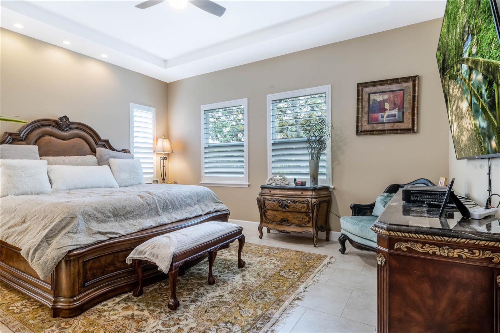 16'6" x 14' Master Bedroom w/ ceramic tile floors, Plantation style shutters, recessed lighting & tray ceiling