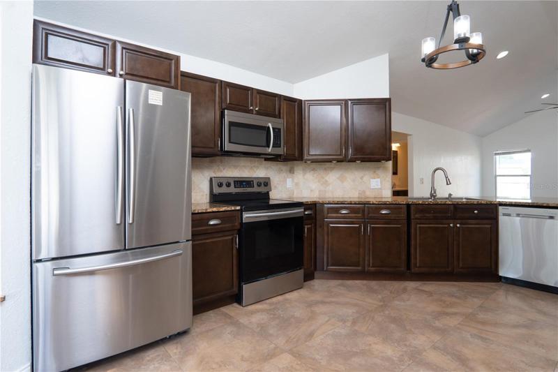 Kitchen with oven, refrigerator, storage cabinets.
