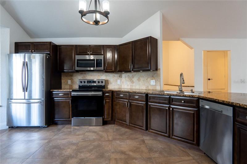 Kitchen with oven, refrigerator, storage cabinets.