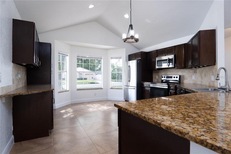 Kitchen with oven, refrigerator, storage cabinets.