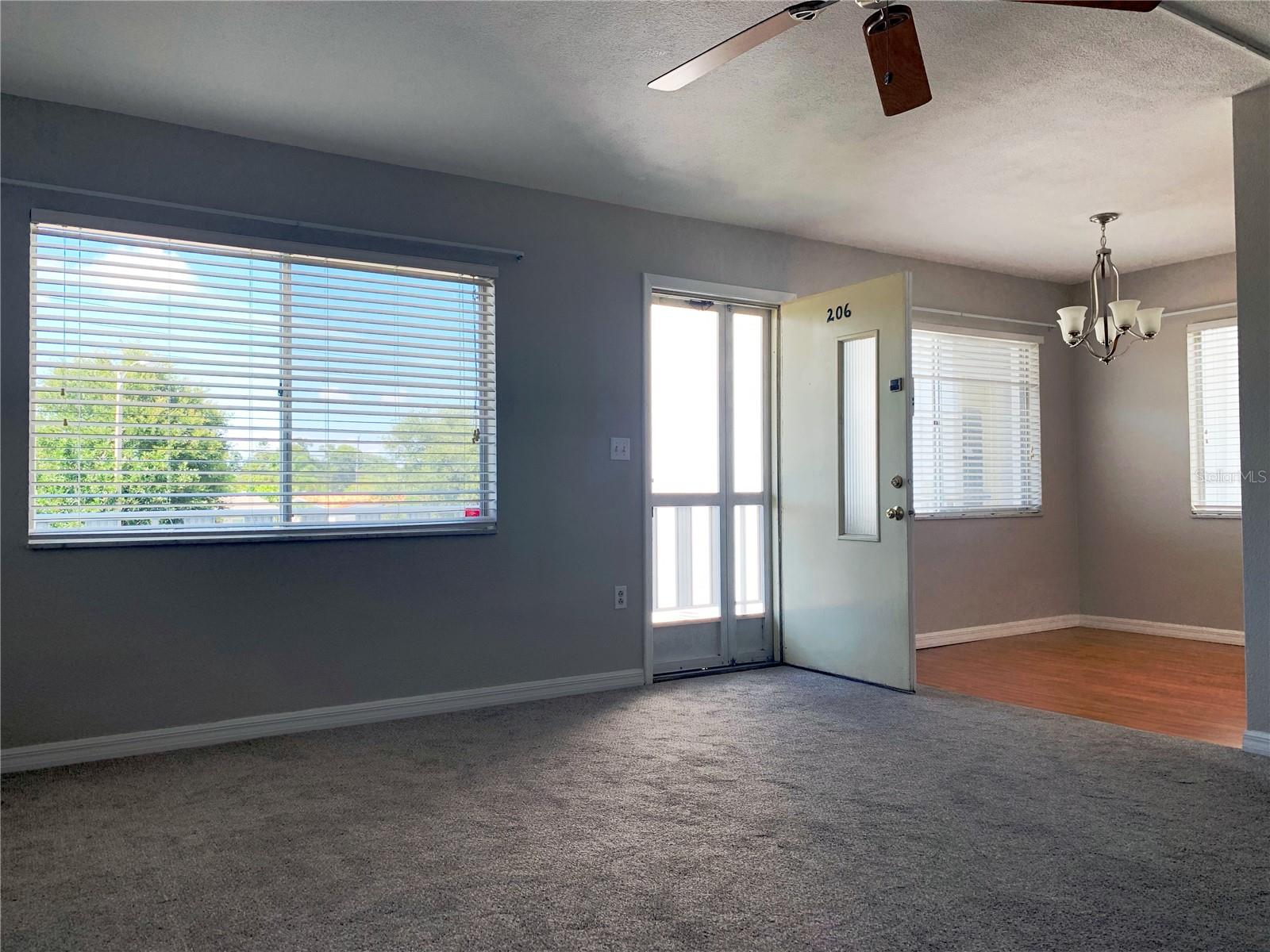 looking back toward the front door from the living room; dining area in the far right of the shot