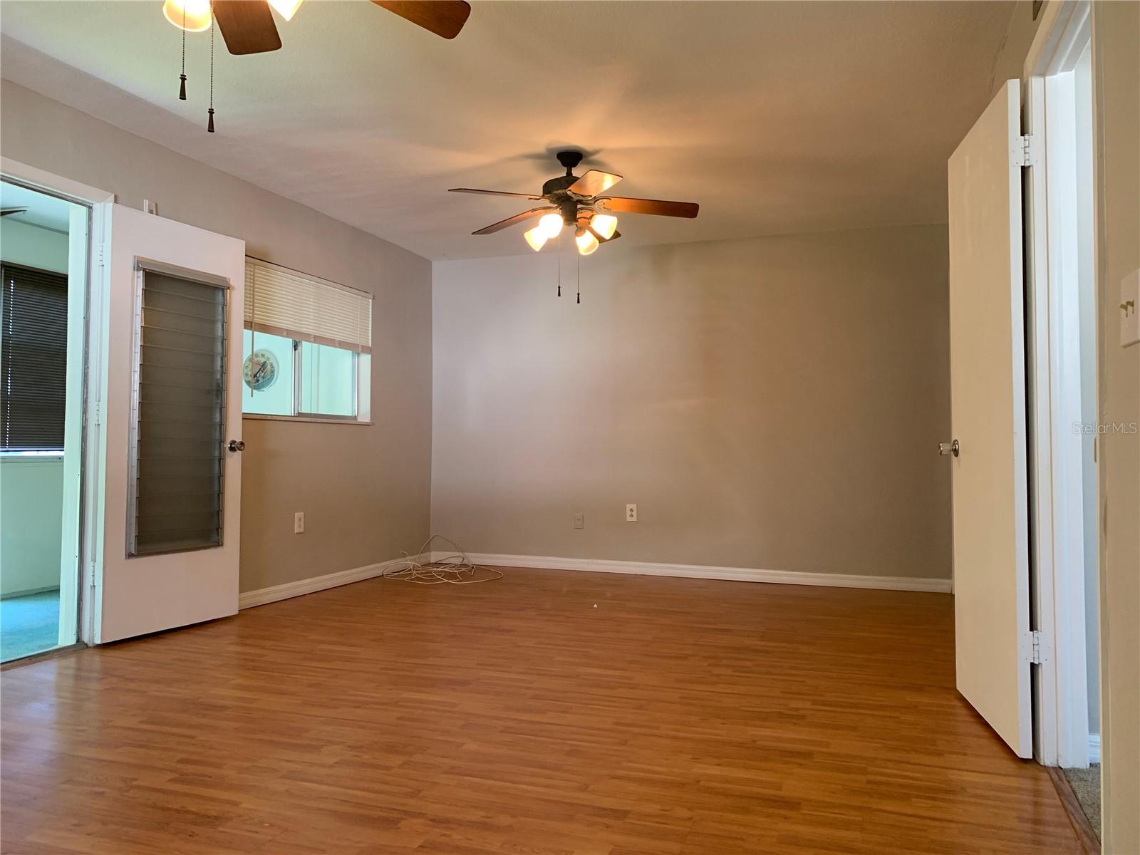 view of huge bedroom; back glass-enclosed porch through the door to the left, back to the main rooms through the door to the right