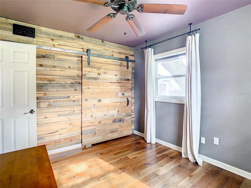 second bedroom with built in drawers and matching barn door