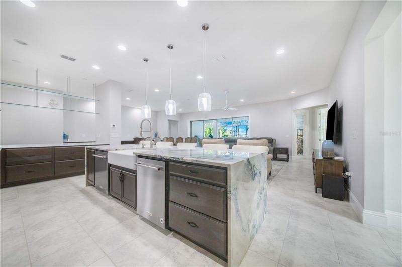 Kitchen Island With Quartzite Waterfall edges offers two dishwashers and is open towards the living areas for entertaining!