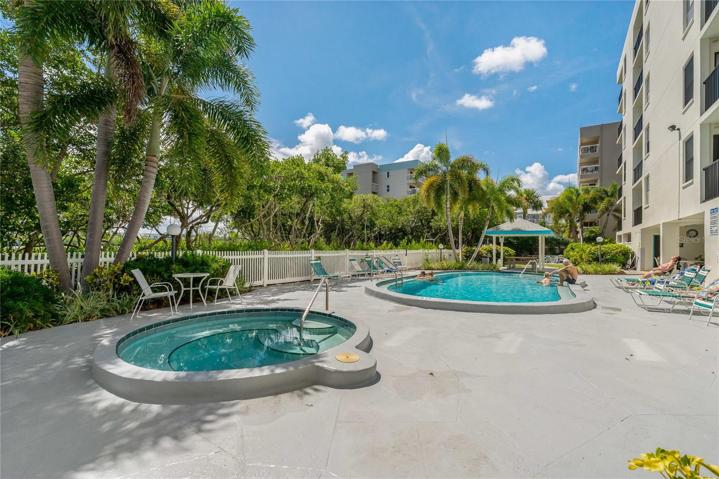 Surrounded by lush greenery is a heated pool w spa