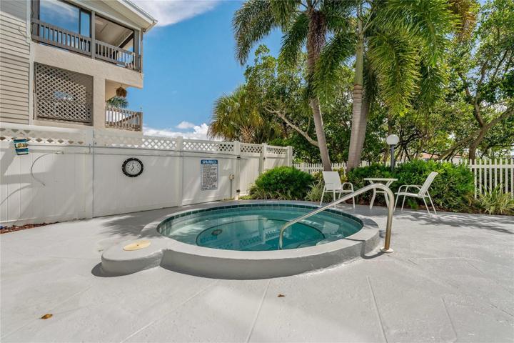 Surrounded by lush greenery is a heated pool w spa