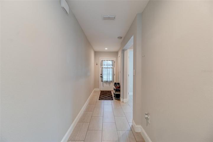 Wide entrance hallway  with custom glass front door.