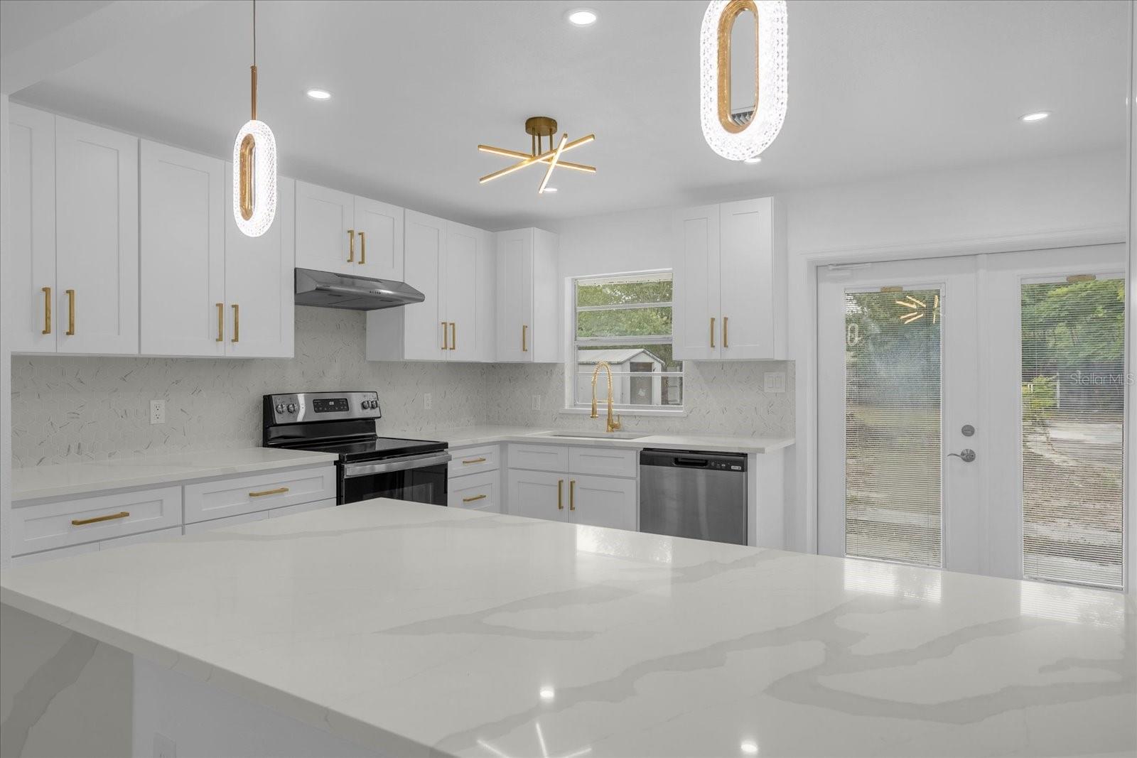 Quartz Countertops, Modern Brass lighting fixtures and cabinet hardware
