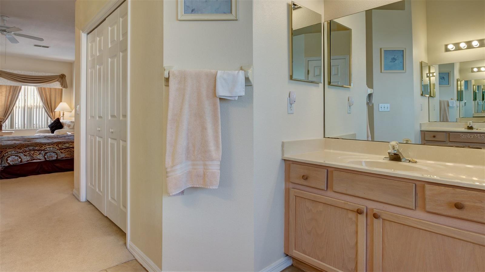 One of two walk-in closets can be seen when looking back into the master bedroom from the bathroom
