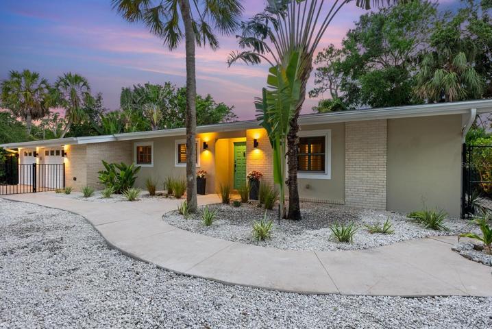 Majestic palms and Live Oak trees grace the front of the property.