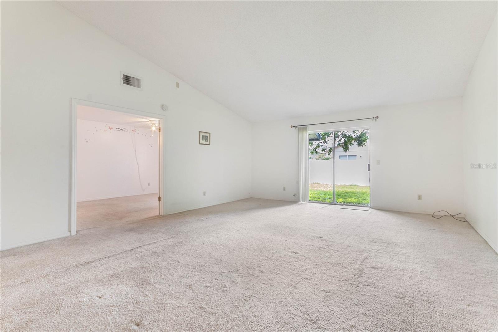 Spacious living room with sliding door leading to yard