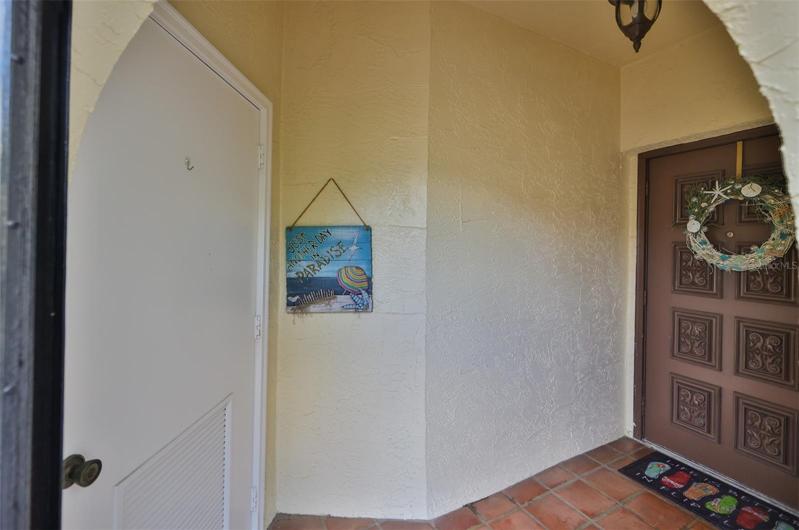 Door to storage room on left and front door on right.