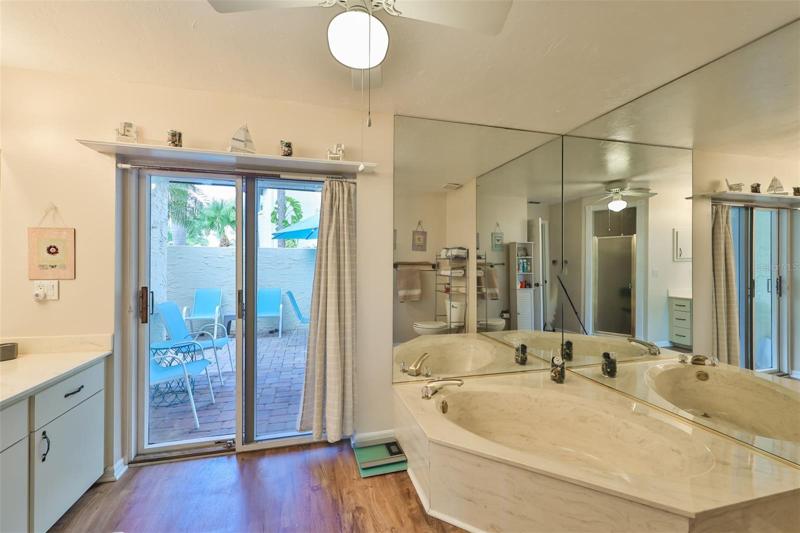 Primary bathroom w/soaking tub & access to courtyard.