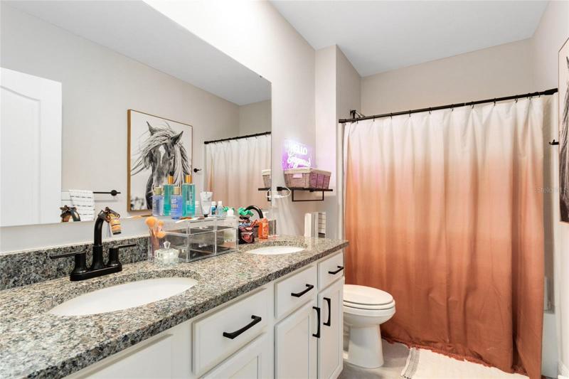 The full hall bath boasts a granite topped vanity and a tub/shower combo.