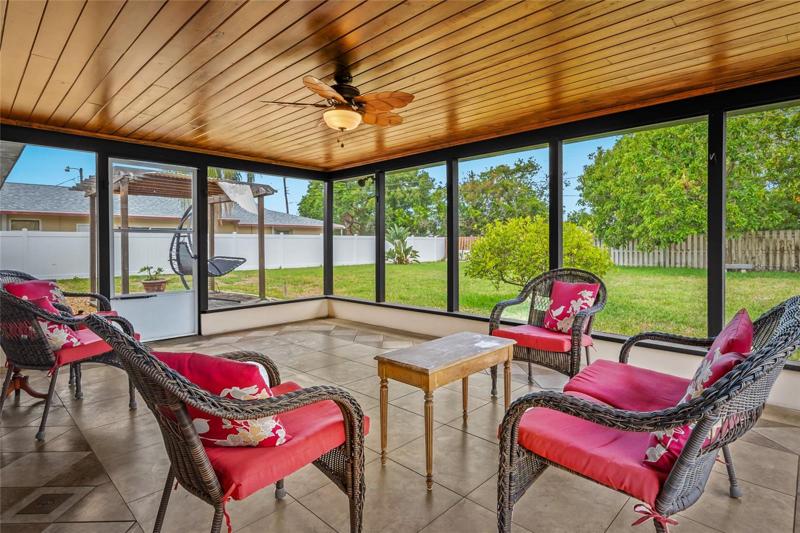 Enjoy sitting on the large covered and screened in Lanai, watching your oversized yard with fruit trees