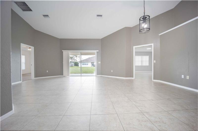 Living area with access to master bedroom, spare bedroom, and sliding glass doors to backyard