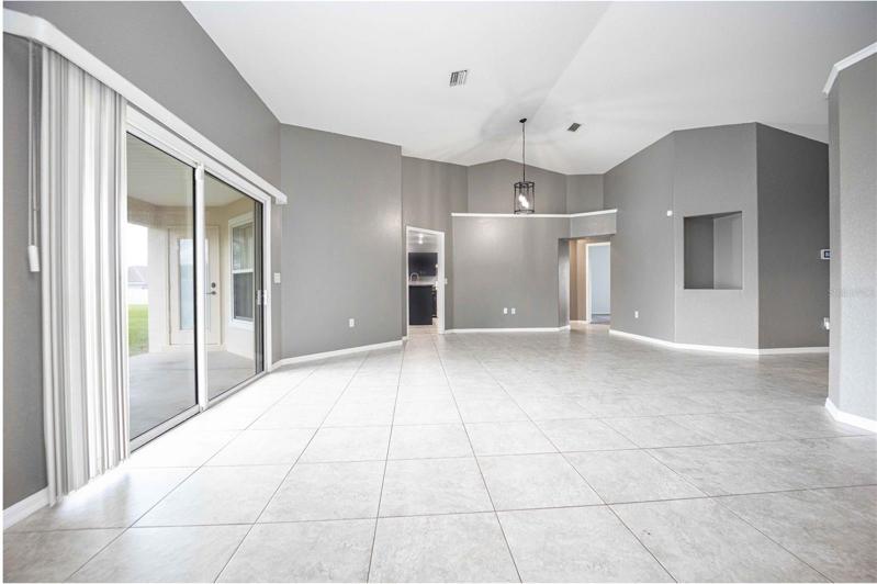 Living area with access to kitchen and sliding glass doors leading to backyard