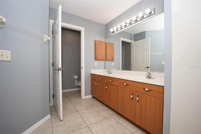 Master bathroom with dual sinks and private lavatory