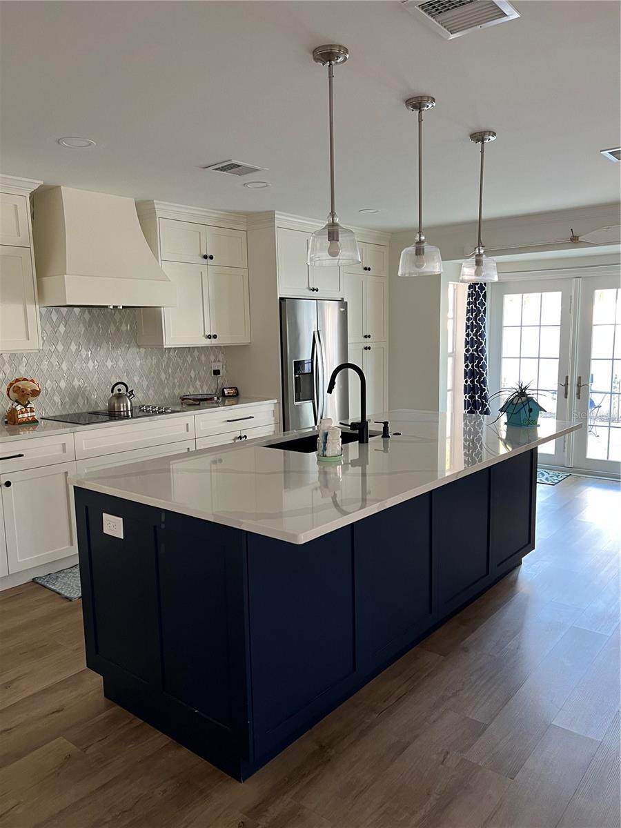 This updated kitchen is a chef's dream that includes a built in convection oven, gorgeous  countertops with a breakfast bar and plenty of storage. The french doors will lead you to the back patio area.
