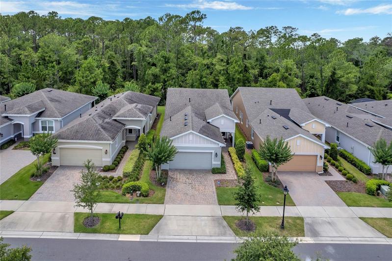 Aerial view of exterior front of home w/ conservation area view behind