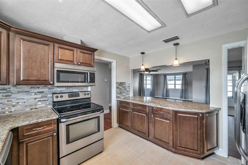 Spacious, open kitchen with granite countertops, Large, Undermount Sink with Window above, Cherry cabinets, Stainless Steel Appliances, and a pass through countertop bar to the Dining Room.