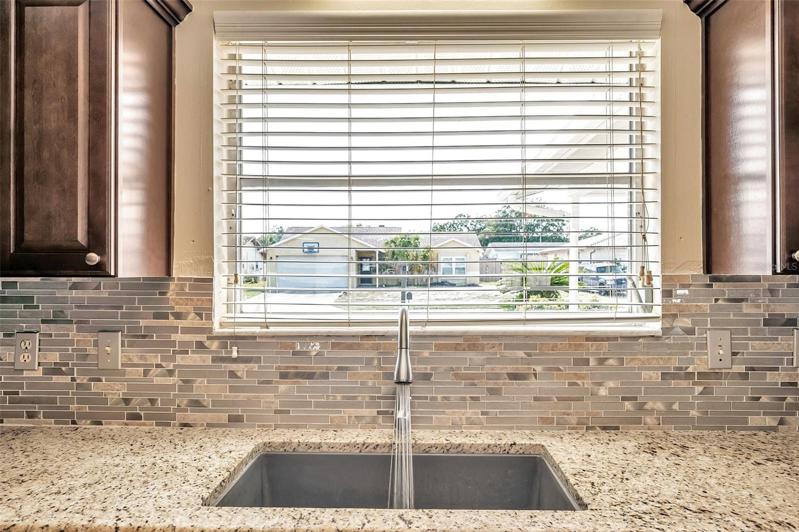 Spacious, open kitchen with granite countertops, Large, Undermount Sink with Window above, Cherry cabinets, Stainless Steel Appliances, and a pass through countertop bar to the Dining Room.