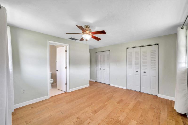 Primary bedroom with full Ensuite Bathroom with large Walk-In Shower, Large Vanity,  lots of natural light, ceiling fan, curtain rods and drapes.