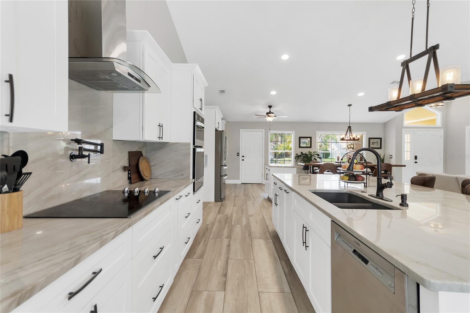 The stainless steel appliances, including built-in ovens and a stainless steel hood, provide a sleek and contemporary look.