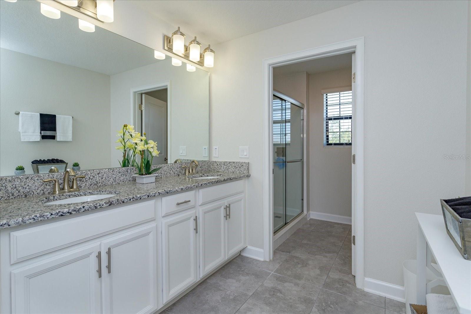 Upstairs hall bath has two sinks and a separate shower and toilet area