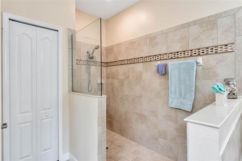 Handicap Accessible Tiled Shower Surrounded by Decorative Listello Tile