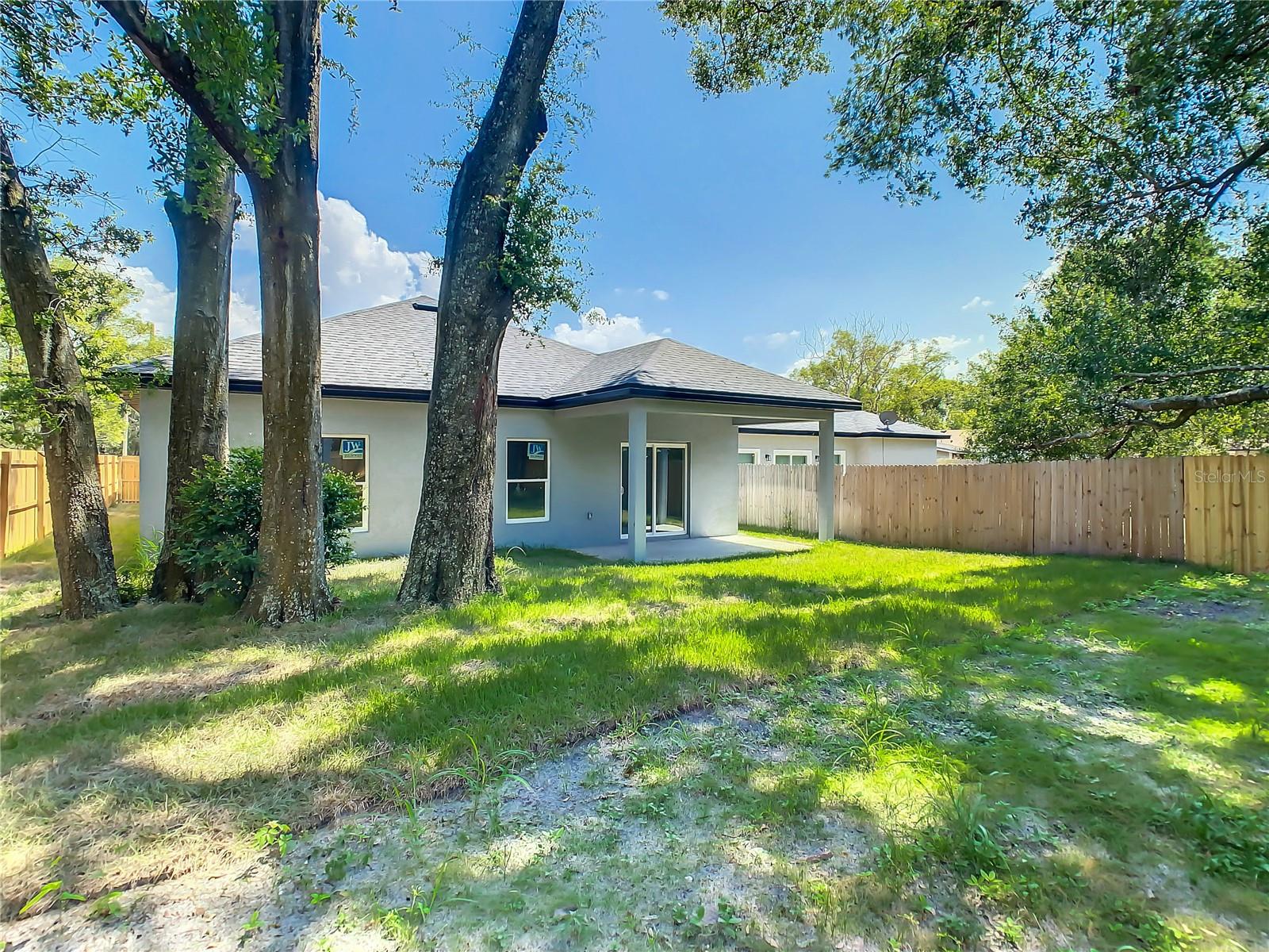 Large backyard fenced with covered porch and shade trees!