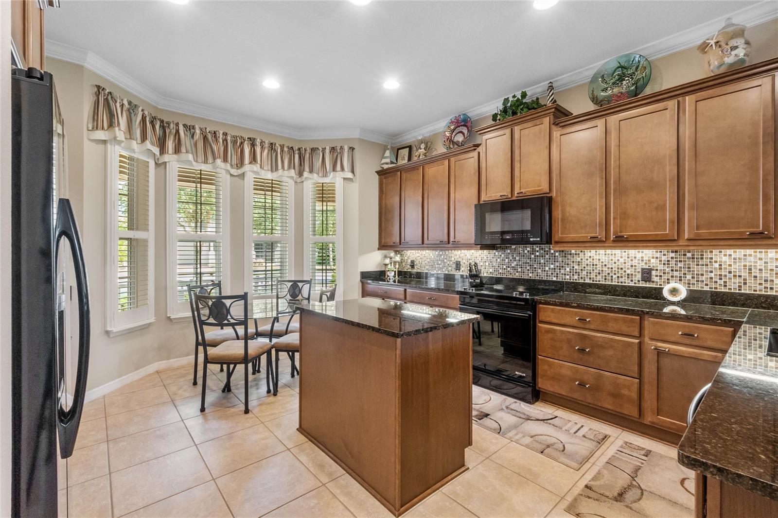 Well-appointed Kitchen with crown molding, island and breakfast nook.