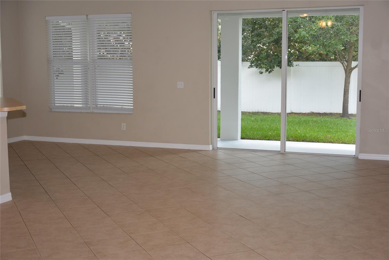 Great room leads to partially fenced backyard with new sod