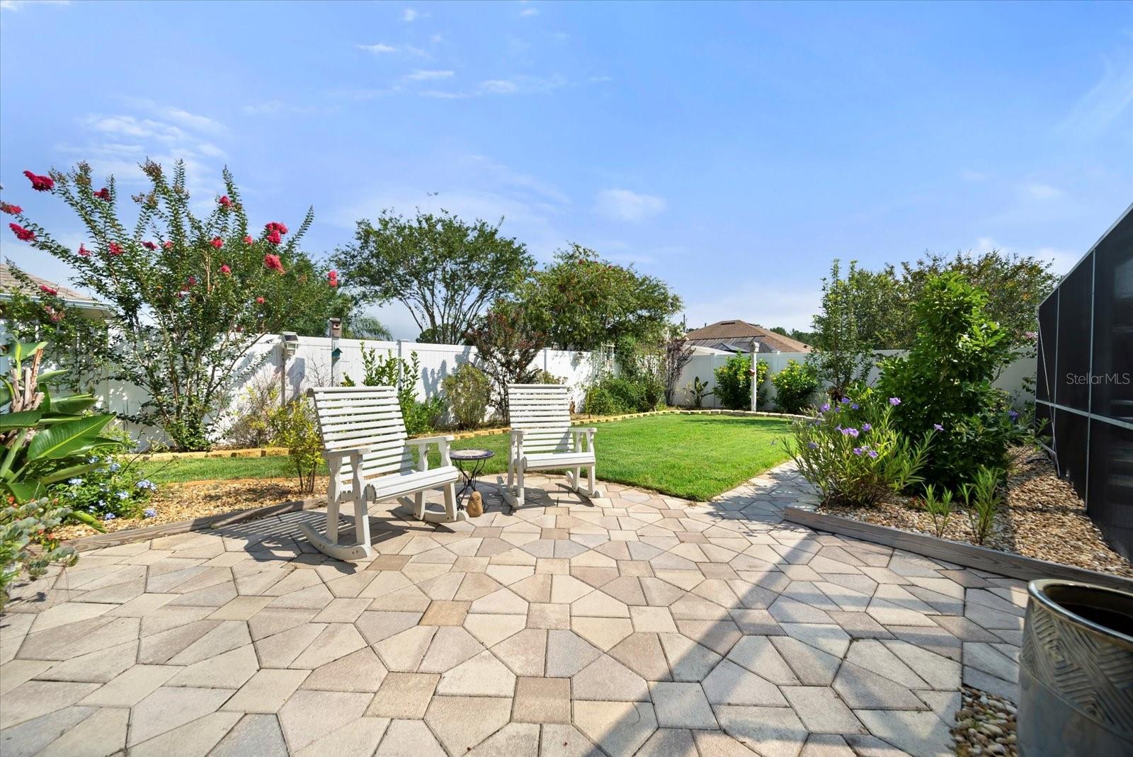pavers off the pool area with lush landscaping
