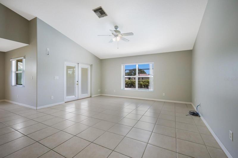 French doors in living room leading out to the pool and covered patio