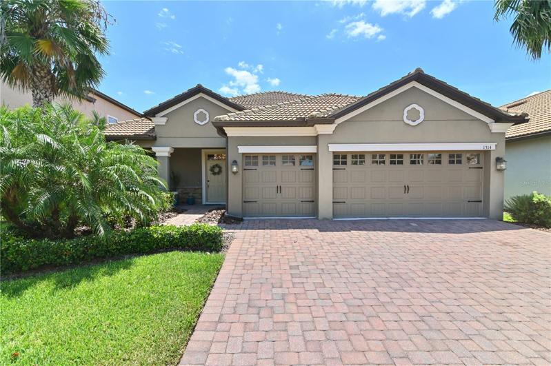 Front exterior with beautiful landscaping and brick paver driveway, front entry walk and patio.