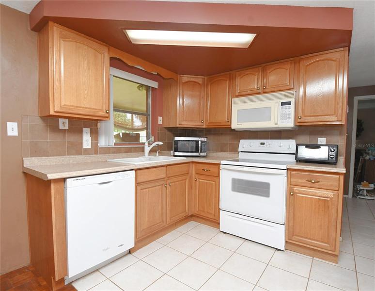 The kitchen has a solid surface counter top adorned with a neutral tile backsplash.